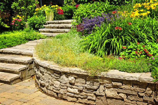 Natural stone retaining wall with flowers and plants